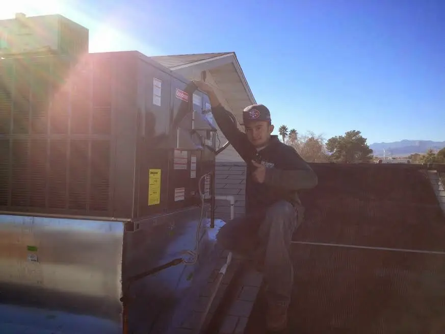 HVAC technician performing AC Tune-Up on a rooftop unit in Manteca
